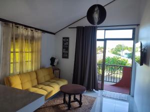 O'hale Perry في Pirae: غرفة معيشة مع أريكة صفراء ونافذة