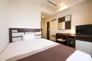 Un pat sau paturi într-o cameră la Urban Hotel Minami Kusatsu