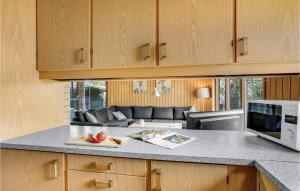 a kitchen with a counter top with a microwave at Awesome Home In Væggerløse With Kitchen in Marielyst