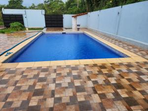 a swimming pool in a backyard with a tile floor at El Olimpo in Puerto Iguazú
