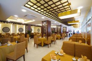 a restaurant with yellow tables and chairs and people in the background at Dong Khanh Hotel in Ho Chi Minh City