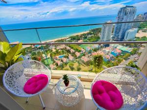 a balcony with two chairs and a view of the ocean at Erica's House - The Sóng Vũng Tàu Condotel Căn hộ biển 5 sao hồ bơi vô cực - The Song Vung Tau Condotel 5-star beach view apartment with infinity pool in Vung Tau