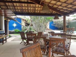 a restaurant with wooden tables and chairs and a blue wall at Pousada El Capitan in Barra Grande