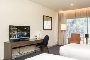 a hotel room with a desk with a television on it at Alexandra Hills Hotel in Cleveland