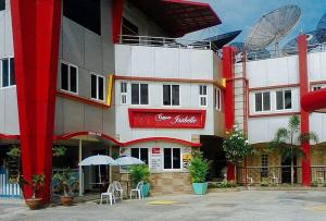 Hinatuan的住宿－RedDoorz @ Isabelle Tourist Hotel Hinatuan，一座大建筑前面设有桌子和遮阳伞