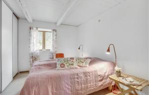 a white bedroom with a pink bed and a table at Awesome Home In Ask With 2 Bedrooms And Wifi in Maribo