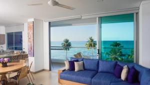 - un salon avec un canapé bleu et une vue sur l'océan dans l'établissement Magico Apartamento Frente al Mar 4 Habitaciones PAZ345, à Coveñitas