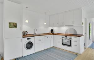 a kitchen with white cabinets and a washer and dryer at 2 Bedroom Lovely Home In Vig in Vig