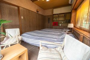 a bedroom with a bed and two chairs at Villa Higashi Fujita Resort in Moroyose