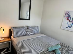 a bedroom with a bed and a desk with a mirror at Cornelias Cottage Mount Gambier Central in Mount Gambier