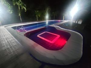 een zwembad 's nachts met een rood licht bij Estupenda casa campestre para tu familia y amigos! in Villavicencio