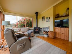 sala de estar con sofá y chimenea en Blue Wren Cottage Farm Stay, en Yanakie