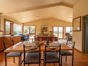 cocina y sala de estar con mesa de madera y sillas en Blue Wren Cottage Farm Stay, en Yanakie