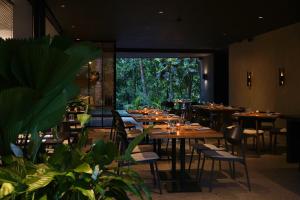 a restaurant with tables and chairs and a large window at Titik Dua in Ubud