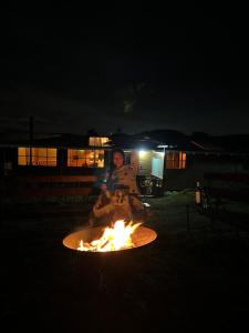 a person sitting around a fire at night at ReverdeSer Glamping in Tabio