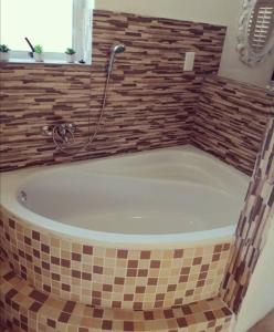 a bath tub with a shower in a bathroom at Villa Saira-Holiday villa across the beach! in KwaDukuza