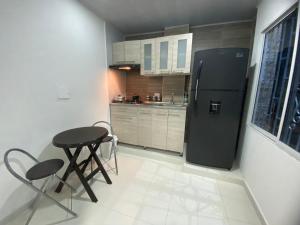 a kitchen with a black refrigerator and two chairs at Hostal La Princesa in Cartagena de Indias