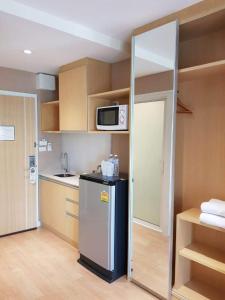 Il comprend une petite cuisine équipée d'un réfrigérateur et d'un four micro-ondes. dans l'établissement Maysa Condo By Saensook, à Hua Hin