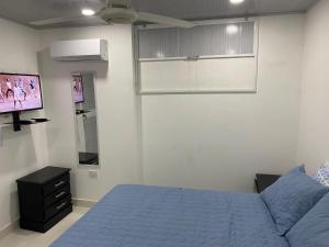 a bedroom with a bed and a flat screen tv at Hostal La Princesa in Cartagena de Indias