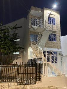 un edificio blanco con escaleras y una valla en Hostal La Princesa, en Cartagena de Indias