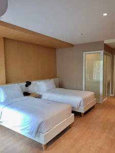 - une chambre avec deux lits et une table avec une lampe dans l'établissement Maysa Condo By Saensook, à Hua Hin