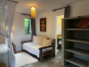 een slaapkamer met een bed, een stoel en een raam bij Casa Viva Trancoso in Trancoso