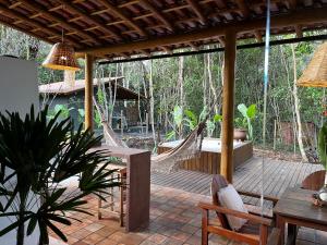 a patio with hammocks and a table and chairs at Casa Viva Trancoso in Trancoso