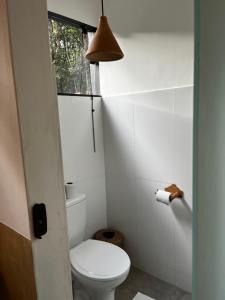 a small bathroom with a toilet and a window at Casa Viva Trancoso in Trancoso