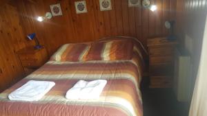 1 dormitorio con 2 camas y toallas. en San martin de los andes cabaña en San Martín de los Andes
