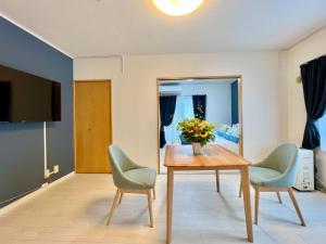 a living room with a table and two chairs at Sapporo Residential Juno in Sapporo
