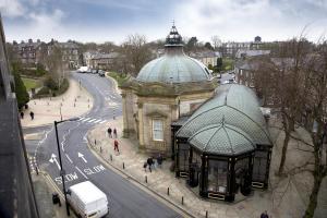 stary budynek ze szklaną kopułą obok ulicy w obiekcie Royal Parade Apartments w mieście Harrogate