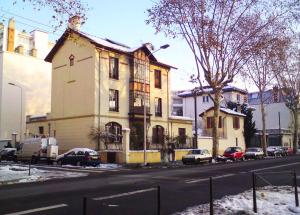 ein Haus an der Straßenseite mit geparkten Autos in der Unterkunft Félix dOrt in Lyon