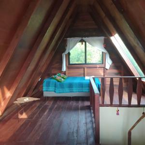 a bed in the middle of a room in a attic at Eco Aldea kinich Ahau in Xpujil
