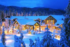 une maison recouverte de lumières de Noël dans la neige dans l'établissement Tenaya at Yosemite, à Fish Camp