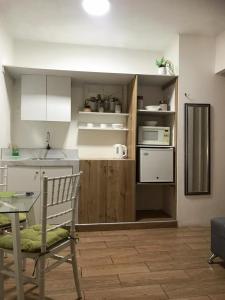 a kitchen with a table and a chair in a room at Los Soles Suite Mall del Sol Guayaquil Airport in Guayaquil