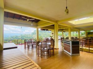 a restaurant with tables and chairs and a view of the mountains at Nature Walk Resort in Kandy