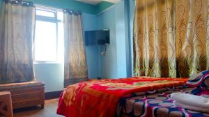 een slaapkamer met een bed en een raam met gordijnen bij Sunshraya Homestay in Darjeeling
