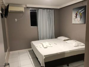1 dormitorio pequeño con 1 cama con sábanas blancas en Iapi Hotel, en Salvador