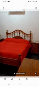 1 dormitorio con cama roja con marco de madera en Turismo en san Rafael Mendoza en San Rafael