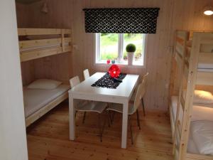 ÅshammarにあるVLS Stugbyのテーブルと二段ベッド2台が備わる客室です。
