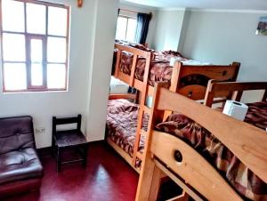 Cette chambre comprend 4 lits superposés et une chaise. dans l'établissement Andes Hostel, à Huaraz