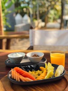 een bord groenten en fruit op een tafel met sinaasappelsap bij Club de Patos in Sisal