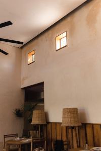 twee tafels en stoelen tegen een muur met twee ramen bij Club de Patos in Sisal