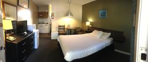 um quarto de hotel com uma cama e uma cozinha em Ray Lyn Motel em Trail
