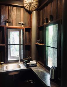 a kitchen with a sink and two windows in it at Luboa Hut - Tiny House in Ko Jum