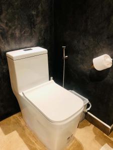 a white toilet in a bathroom with a roll of toilet paper at Luboa Hut - Tiny House in Ko Jum