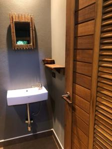 a bathroom with a white sink and a mirror at Luboa Hut - Tiny House in Ko Jum
