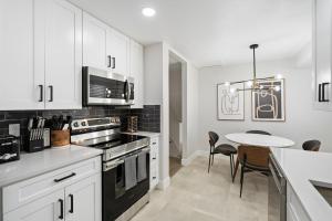 a kitchen with white cabinets and a table with chairs at @ Marbella - Spacious and Modern Home in Arvada in Arvada