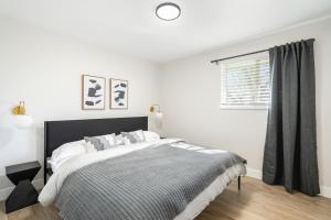 a white bedroom with a bed and a window at @ Marbella - Spacious and Modern Home in Arvada in Arvada