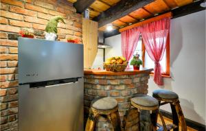 a kitchen with a refrigerator and a counter with stools at Beautiful Home In Klenovnik With Sauna in Klenovnik